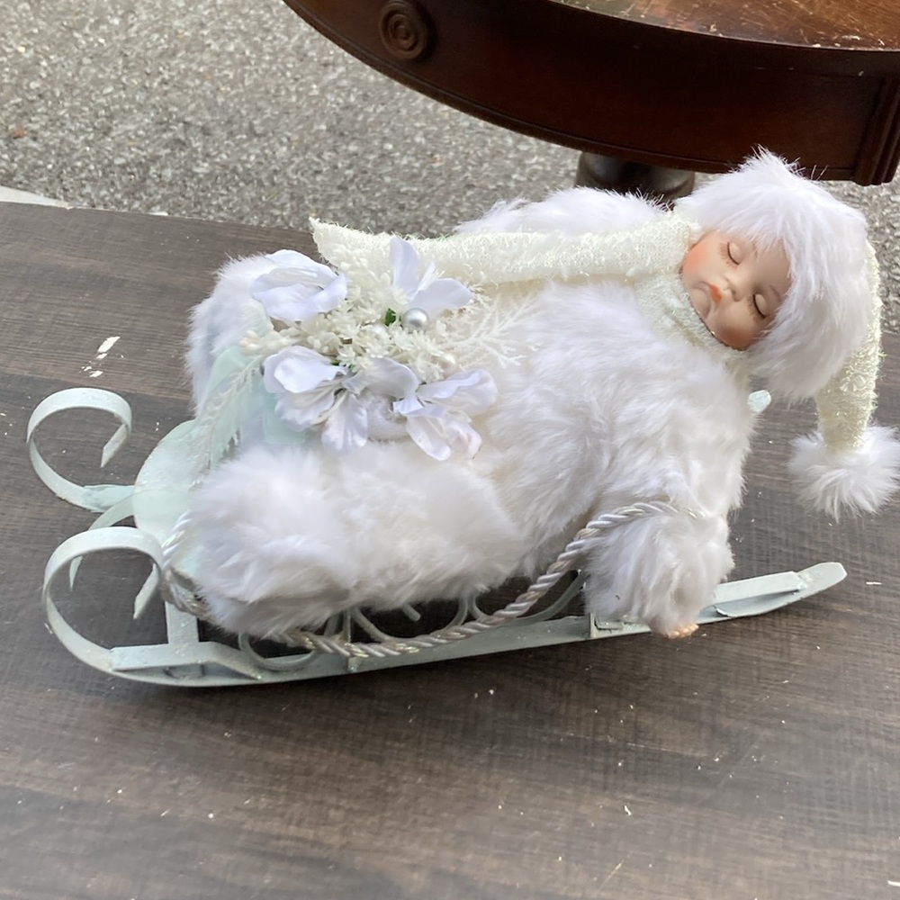 Snowy Porcelain Baby on a Sleigh